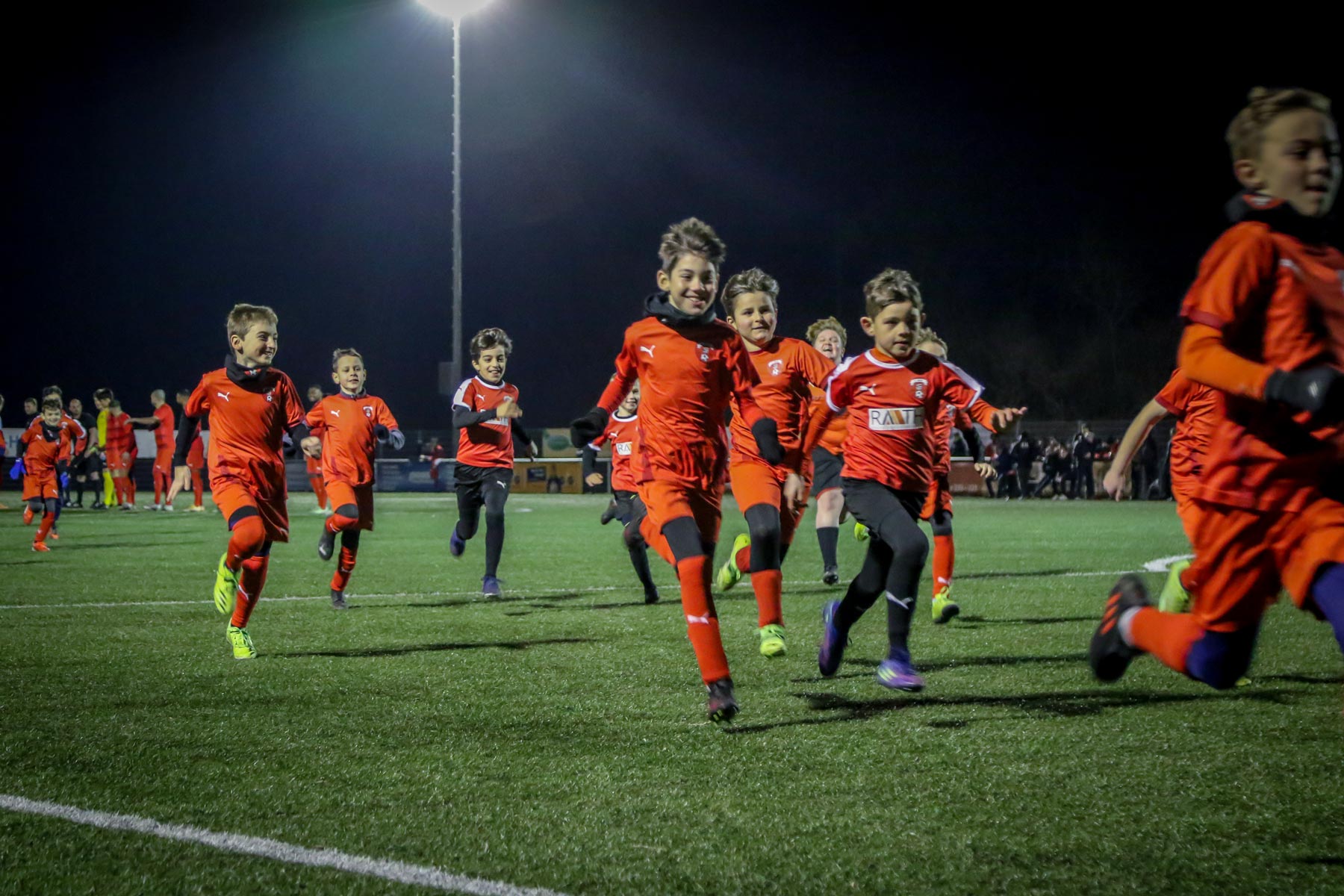 Jugendliche Fußballspieler rennen über den Platz